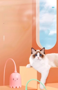 Detail view of pink electric cat toy with flexible mint green tail and cute kitten interaction