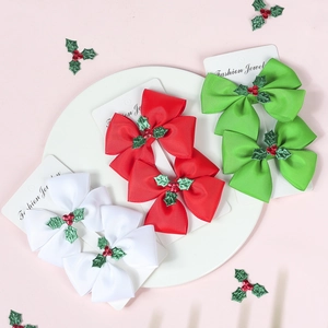 Christmas bow hair clips set with holly leaves and red berries on display card