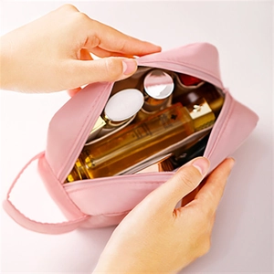 Vue intérieure montrant la grande capacité et la poignée de la trousse de maquillage rose