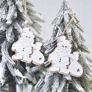 Two wooden Santa Claus hanging ornaments with star cutouts on a snowy Christmas tree branch