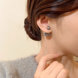 Close-up of elegant double-sided grey pearl earrings worn on a model ear