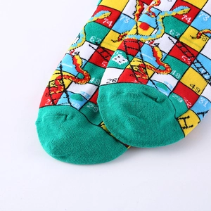 Macro detail of cotton crew socks featuring colorful snake and ladder game patterns