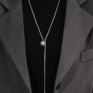 Elegant silver snake chain Y-necklace with a minimalist white pearl pendant on grey blazer