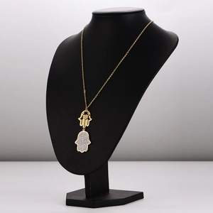 Hamsa-Hand-Halskette in Gold-Finish mit funkelnden Kristallen auf schwarzer Schaufensterpuppe