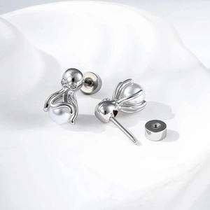 Silver octopus earring with white pearl showing screw back detail on textured background