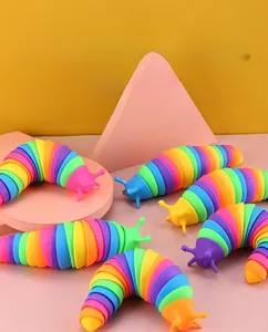 Detail of rainbow fidget slug toy with articulated joints on a pink circular base