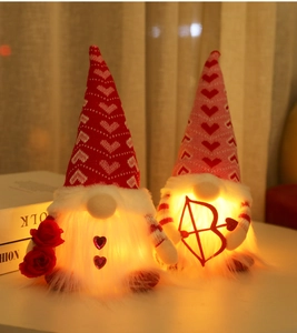 Close-up of glowing Valentine's Day gnomes with heart hats and warm LED lights