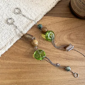 Vintage asymmetric tassel earrings with silver chains, green glass beads and stone charms