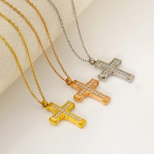 Detailed view of cross necklaces in gold, rose gold and silver with zircon inlay