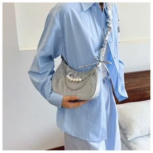 Detail of silver velvet dumpling bag with pearl charm and bow decoration for women