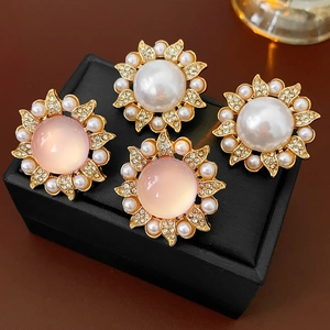 Vue macro de boucles d'oreilles vintage fleurs avec perles, gemmes roses et diamants