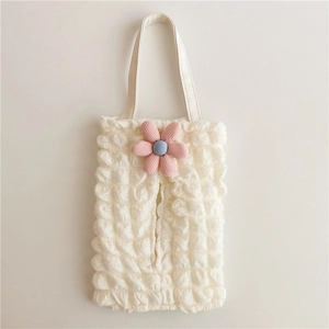 Detail of cream bubble fabric car tissue holder with pink knitted flower and soft texture
