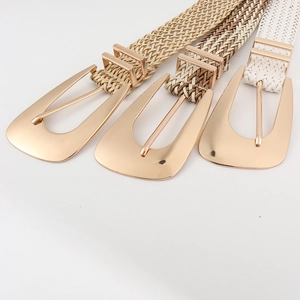 Detail of three woven straw belts with large irregular gold metal buckles in various colors