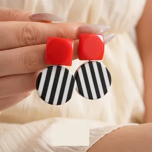 Retro geometric earrings with red square studs and black and white striped resin pendants