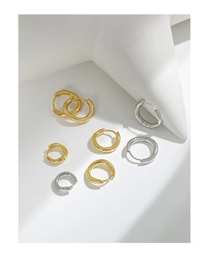 Detail showing 925 sterling silver hallmark on irregular hoop earrings in gold and silver