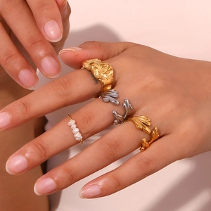 Close-up of gold and silver plated rings with pearls and wings on a hand