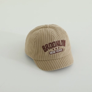Detail der bestickten Buchstaben auf der Retro beige Cord-Struktur Baby-Kappe