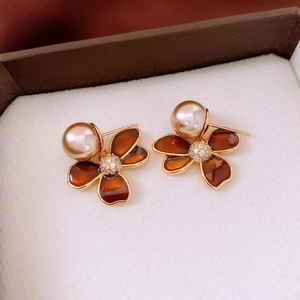Macro detail of amber flower earrings with gold edges, micro-set diamonds and pearls