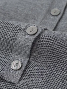 Macro shot of grey knit cardigan detail with marbled buttons and ribbed texture