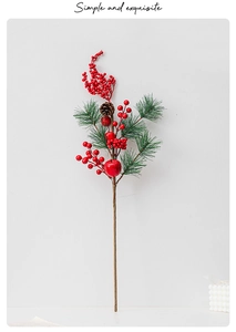Detail of Christmas pine branch with red berries and pine cones on a light background