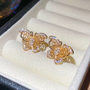 Close-up of gold-plated butterfly stud earrings with sparkling cubic zirconia inlay