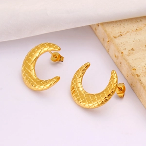 Elegant gold crescent moon earrings with diamond pattern engraving on a stone base