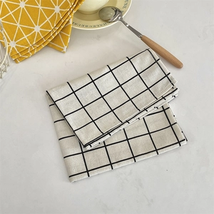 Macro shot of black and white plaid cotton linen placemat on marble tabletop surface