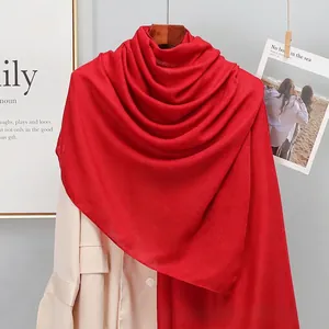 Red cotton linen scarf paired with beige trench coat for a stylish layered spring look