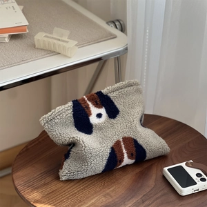Sac à bandoulière en peluche avec oreilles de chien sur une table en bois brun