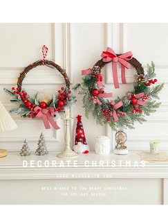 Detail of lit Christmas wreath with pine cones and red berries on a white fireplace