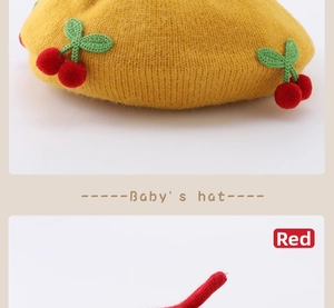 Detail of baby ginger knit hat with cute red cherry 3D decorations and yarn texture