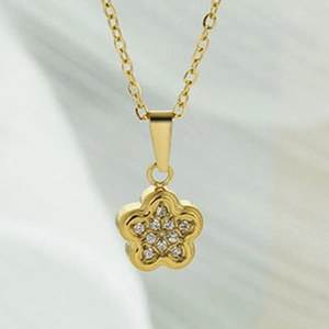 Detail view of a gold floral pendant featuring micro-paved sparkling cubic zirconia