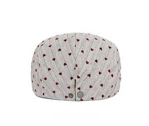 Rear view of herringbone newsboy hat with embroidered hearts and adjustable buckle