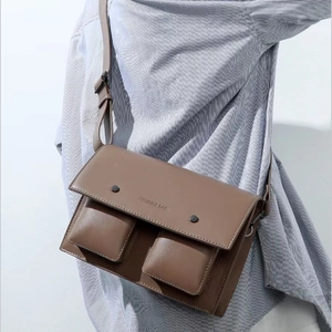 Dark brown leather crossbody messenger bag with dual front pockets and adjustable strap