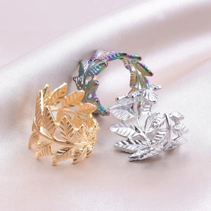 Three laurel leaf open rings in gold, silver, and rainbow colors on pink silk fabric