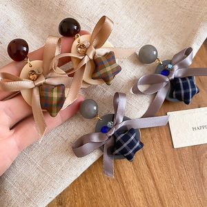 Détail de boucles d'oreilles avec nœud, étoiles en tissu et ruban champagne chic