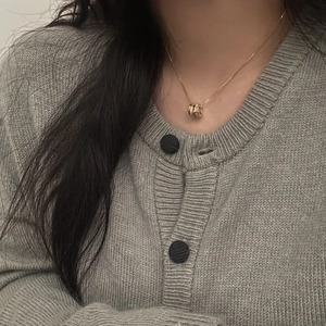 Elegant gold cylinder necklace with white inlay on a model for casual daily wear