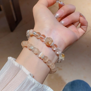 Gros plan de bracelets en perles de cristal blanc et jaune avec intercalaires fleurs en argent