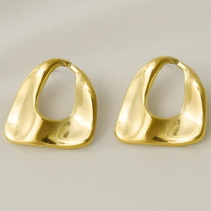 Detailed close-up of golden irregular oval stud earrings with high-polished metal finish