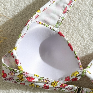 Détail du haut de bikini floral montrant les bonnets intérieurs et les coutures