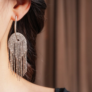 Gros plan de boucles d'oreilles à pampilles en strass sur mannequin avec détails