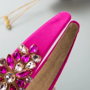 Vue détaillée macro d'un serre-tête en satin rose avec des fleurs en strass brillantes