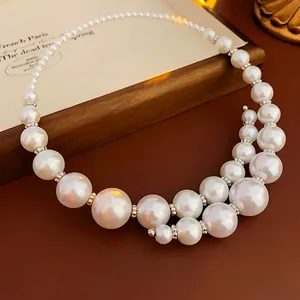 Elegant gradient pearl choker with silver spacers on a vintage brown leather backdrop