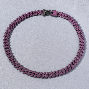 Detail view of hip hop Cuban link necklace with pink diamonds on dark metal base