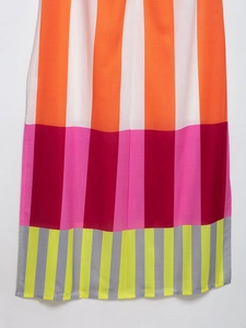 Detail of colorful striped fabric with orange, pink, and yellow hues on a summer dress