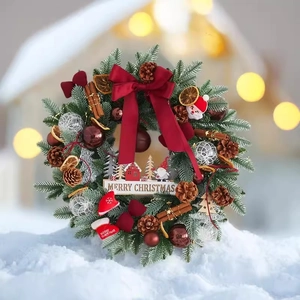 Exquisite Christmas wreath with pine cones, red velvet bow, and ornaments on snowy background