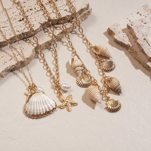 Parure de trois colliers dorés style océan avec coquillages, étoiles de mer et perles de plage