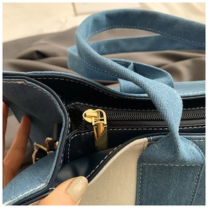 Detail of premium gold metal zipper and stitching on the contrast denim canvas tote bag