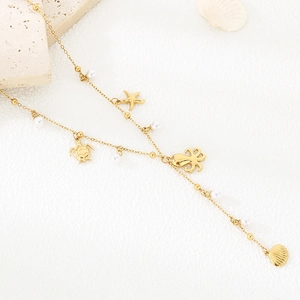 Detail of gold ocean charm necklace with starfish, turtle pendants and pearls