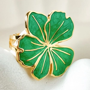 Macro shot of a vintage gold-plated ring featuring green enamel four-leaf clover detail